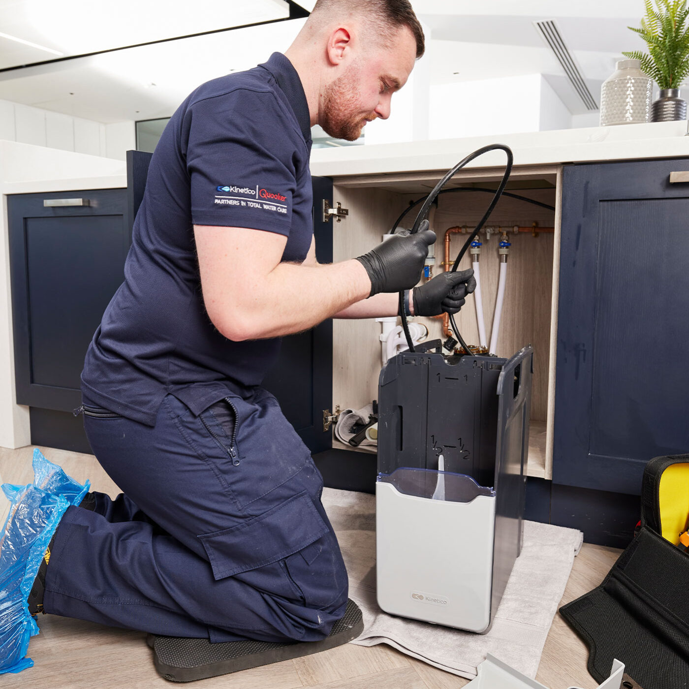 Plumber repairing pipework under kitchen sink